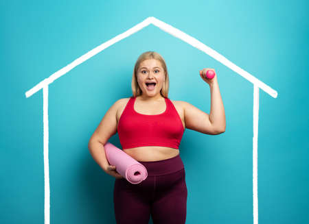 Fat girl does gym at home. satisfied expression. Cyan background