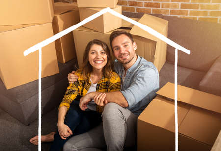 Happy couple have to move and arrange all the packages.の写真素材