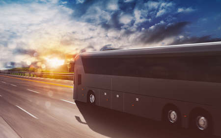Grand tour bus moving fast on the highway at sunsetの写真素材