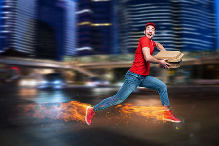 Courier runs fast to deliver quickly pizzas with fiery feet. Cyan backgroundの写真素材