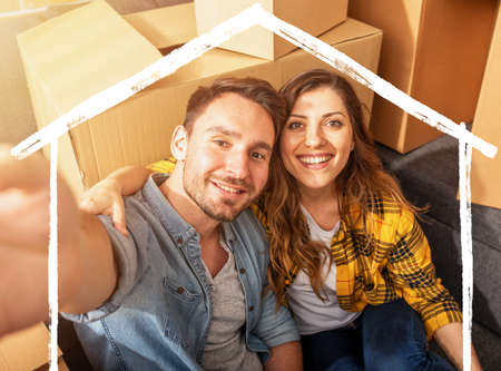 Happy couple have to move and arrange all the packages. Concept of success, change, positivity and futureの写真素材