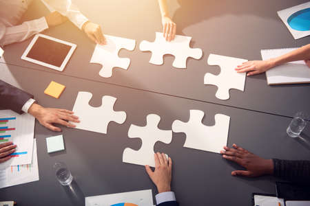 Teamwork of partners. Concept of integration and startup with puzzle piecesの写真素材
