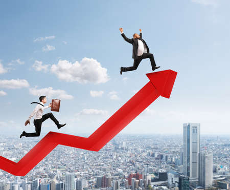 Businessmen run to reach the best results over a growing red statistic arrow. Concept of successの写真素材