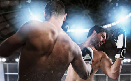 Boxer in a boxe competition beats his opponent.