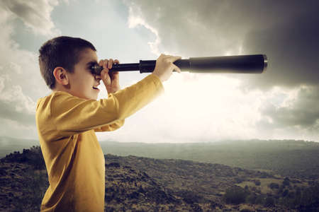 Child with spyglass looks far for a new adventureの写真素材