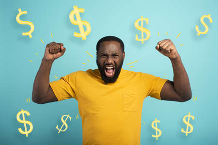 Boy wins money. Amazed and surprised expression face. Light blue backgroundの写真素材