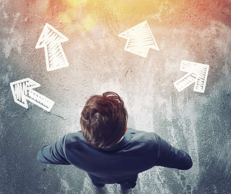 Confused Man have to choose the right arrow to follow. Concept of options, confusion, decision.の写真素材