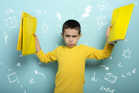 Child is unhappy and angry about too many schoolwork. cyan backgroundの写真素材