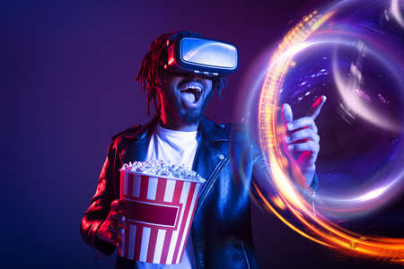 Man with VR glasses and popcorn watches a 3D film
