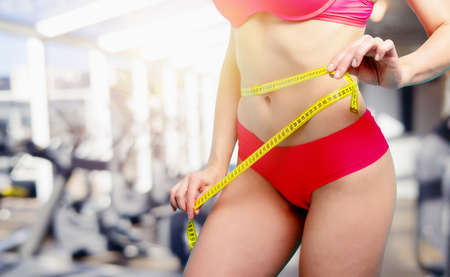 Determinated sport woman has an excellent physical shape and measure with the meter.