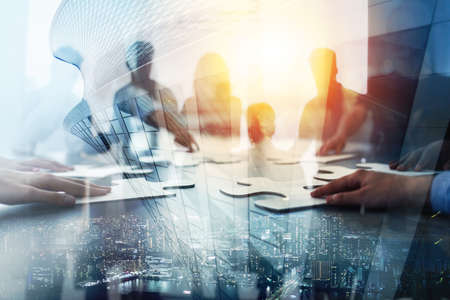 Business teamwork at the office. Workers join puzzle pieces on the desk. Partnership conceptの写真素材