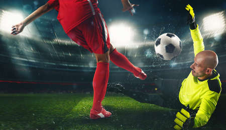 Soccer goalkeeper, in fluorescent uniform, countering the attacker in red uniform
