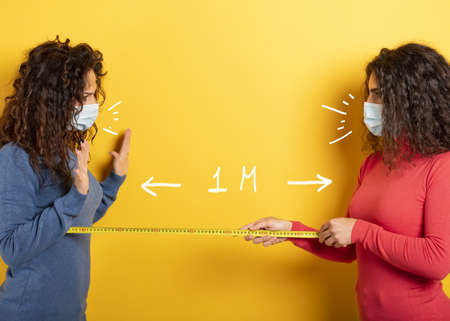 Friends keep distance between them of 1 meter. Concept of codiv-19 rules to avoid pandemic. yellow...