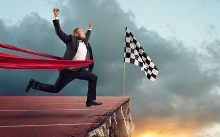 Businessman thinks she has won but there is a precipe after the finishlineの写真素材