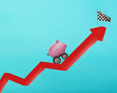 Piggy bank with wheel like a car runs wants to reach the flagの写真素材