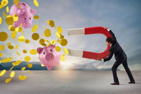 Businessman captures money with a big magnet. concept of earning success.の写真素材