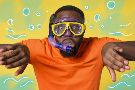 Man with mask ready to swim underwater. yellow backgroundの写真素材