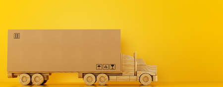 Big cardboard box package on a wooden toy truck ready to be delivered on yellow backgroundの写真素材