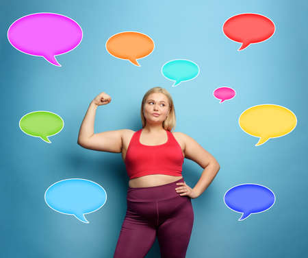 Fat girl does gym at home. thoughtful expression. Cyan background