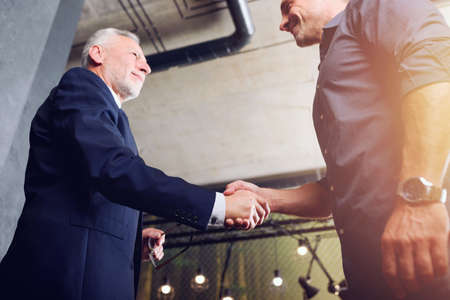 Handshaking business person in office. concept of teamwork and partnership.の写真素材