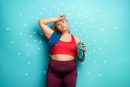 Fat girl does gym at home. tired expression. gyan backgroundの写真素材