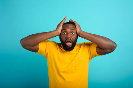 Amazed and shocked expression of a boy over cyan backgroundの写真素材