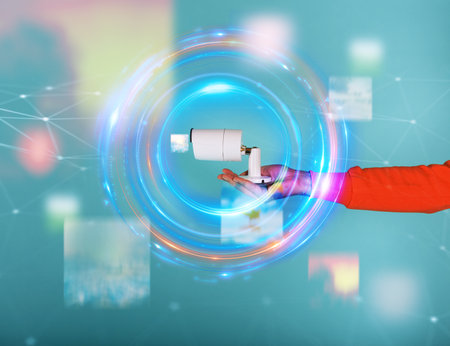 Man holds in hand an ip camera. Cyan backgroundの写真素材