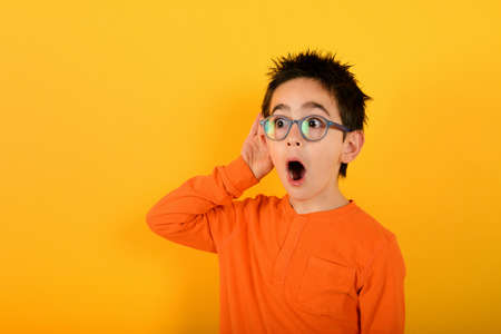 Wondered child ears something. concept of gossip. yellow backgroundの写真素材