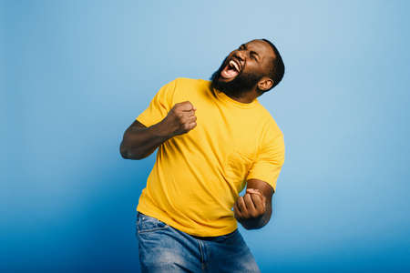 Boy wins something. Amazed and surprised expression face. Light blue backgroundの写真素材