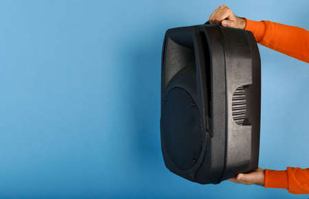 Man holds a big sound box to listen music.