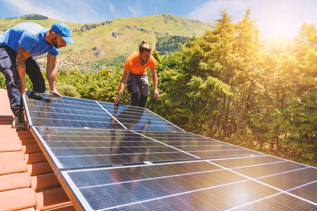 Workers assemble energy system with solar panel for electricity and hot water