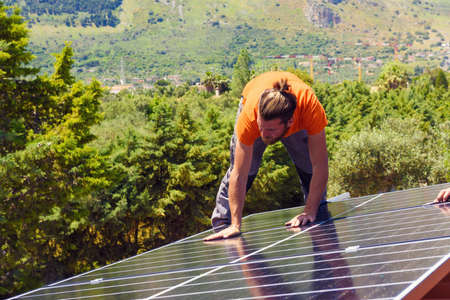 Workers assemble energy system with solar panel for electricity