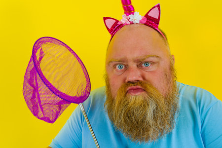 Fat thoughtful man with headband play with sea net