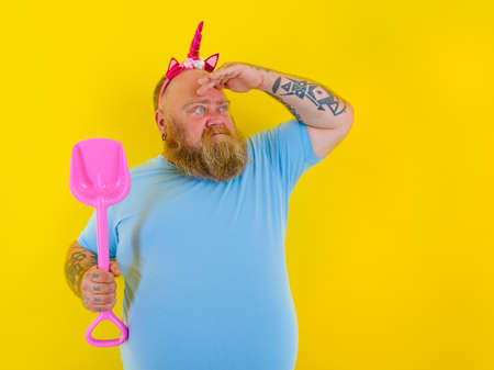 fat man with headband play with sea paddleの写真素材