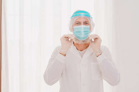 Doctor with mask and face protector is ready to work in hospital