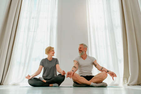 Husband and wife do yoga exercise together at homeの写真素材