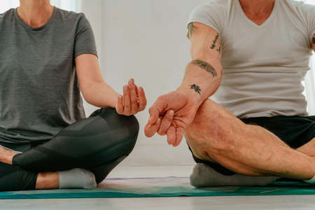 Husband and wife do yoga exercise together at home