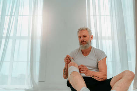 Sportive man applies protective bandage for sport