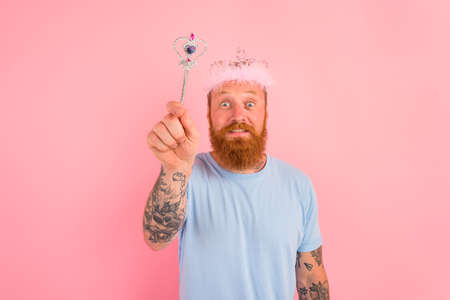 Amazed man with beard and tattoos acts like a princess of a tale