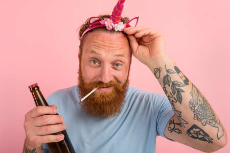 Happy man with beard and tattoos acts like a princess of a tale