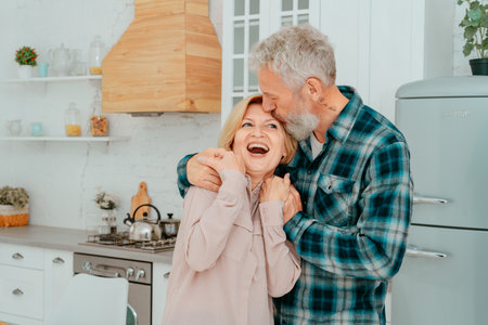 Retired husband and wife hug each other at homeの写真素材