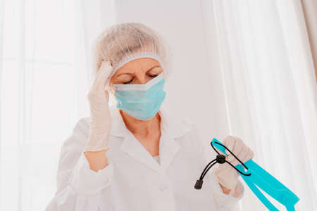 Doctor with face mask and face protector is tired about the covid-19 virus pandemic