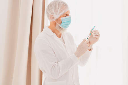 Doctor with syringe is ready to administer the vaccine against covid-19の写真素材