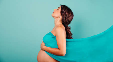Pregnant woman expecting a child caresses her belly