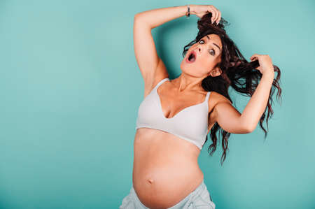 Pregnant amazed woman expecting a child caresses her belly