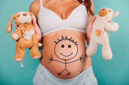 Pregnant woman expecting a child caresses her belly