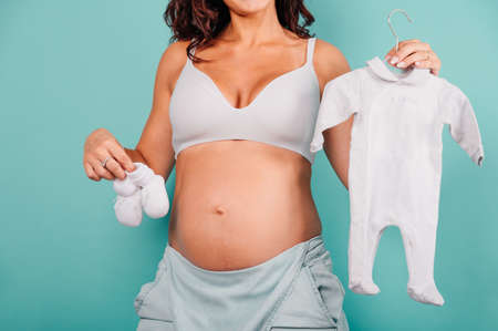 Pregnant mom prepares the clothes for the babyの写真素材