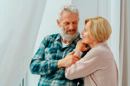 Retired husband and wife hug each other at homeの写真素材