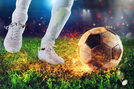Soccer player ready to kick the fiery soccerball at the stadiumの写真素材