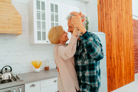 husband and wife dance at home during breakfastの写真素材